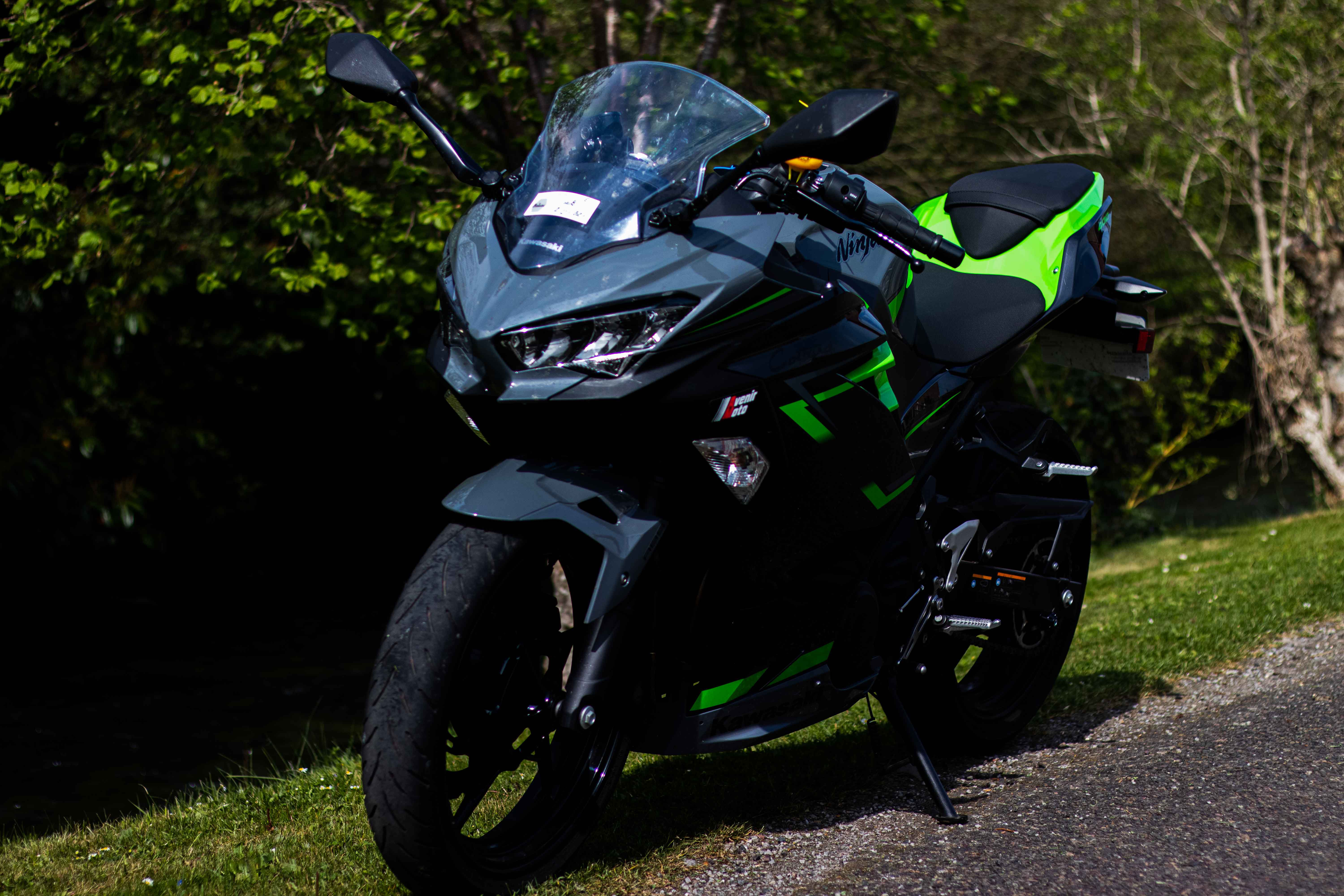 Photo d'une moto noir et verte, vu à trois quart face